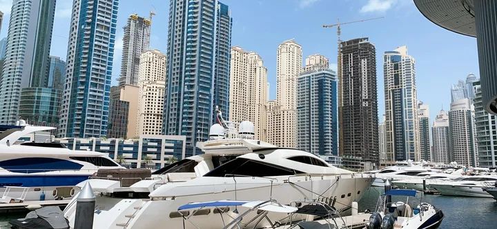 Yachts moored beneath the towers of Dubai Marina, shown as a reference for the waterfront experience